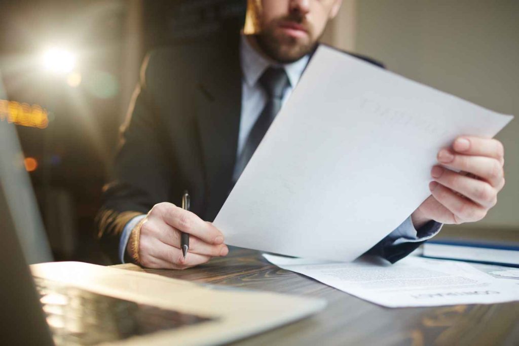 وکیل در حال مطالعه بندهای قرارداد ملکی خرید و فروش ملک